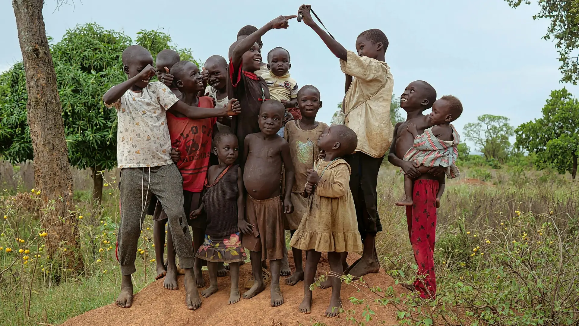 A group of happy children playing together outdoors in rural Uganda.